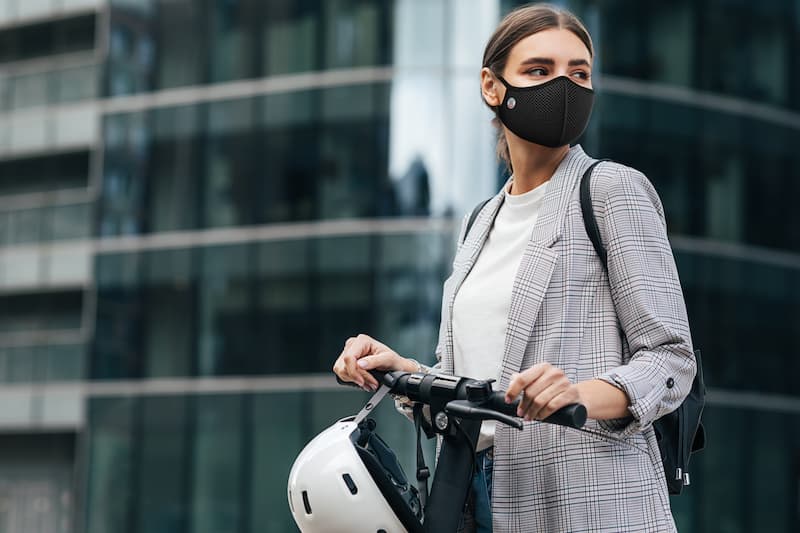femme en trottinette avec un masque antipollution
